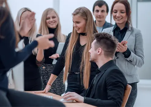 Szczęśliwa grupa robocza bijąca brawo w miejscu pracy